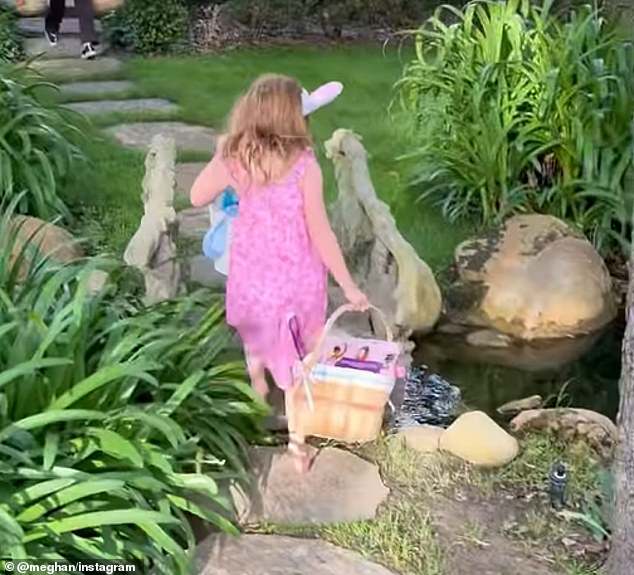 Lilibet wears bunny ears and carries a basket during the Easter egg hunt