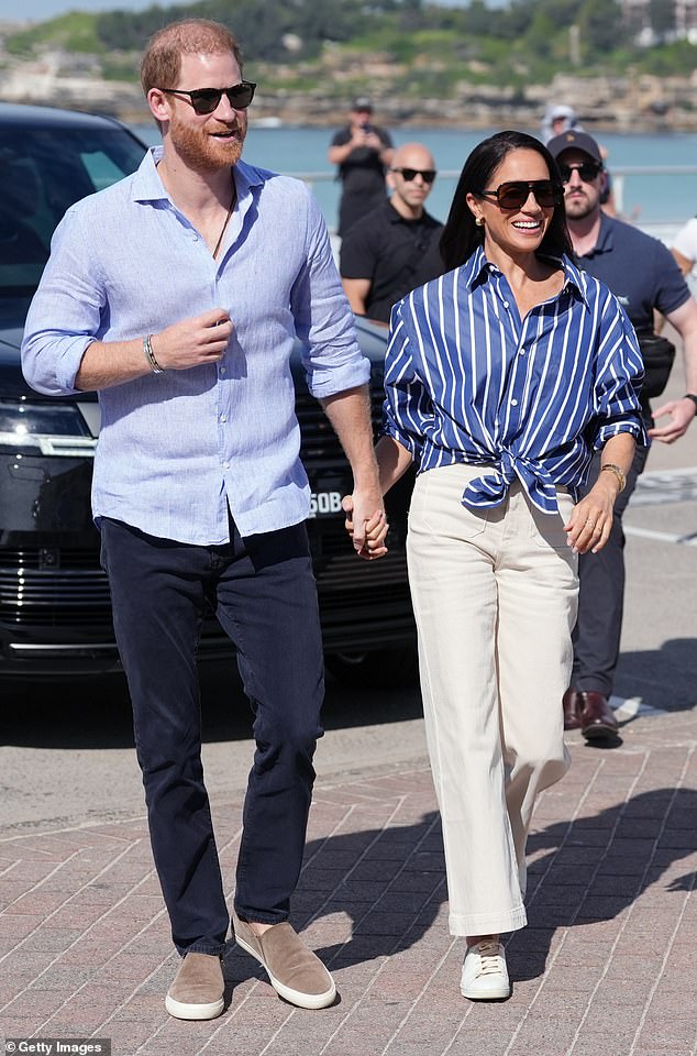 Meghan Markle in a navy-and-white, nautical-inspired look walking with Prince Harry during the Australia swing.