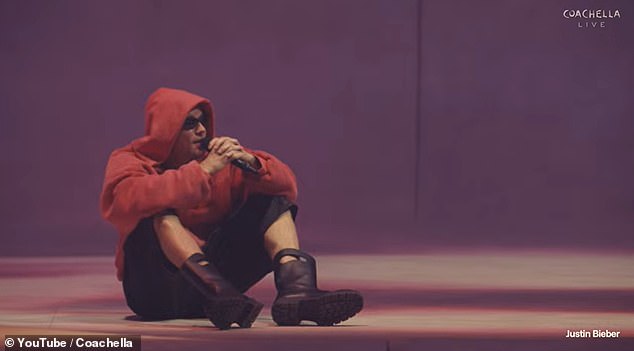 Bieber sits beside a laptop mid-set, cueing clips while singing along at Coachella.