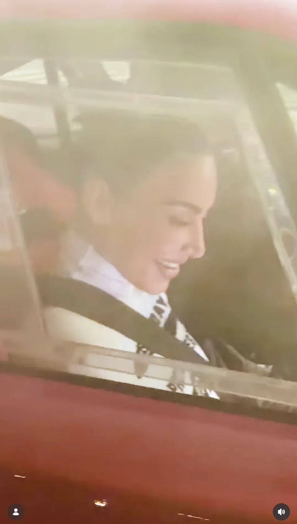 Kim Kardashian smiles in the passenger seat during Lewis Hamilton's Tokyo Reel.