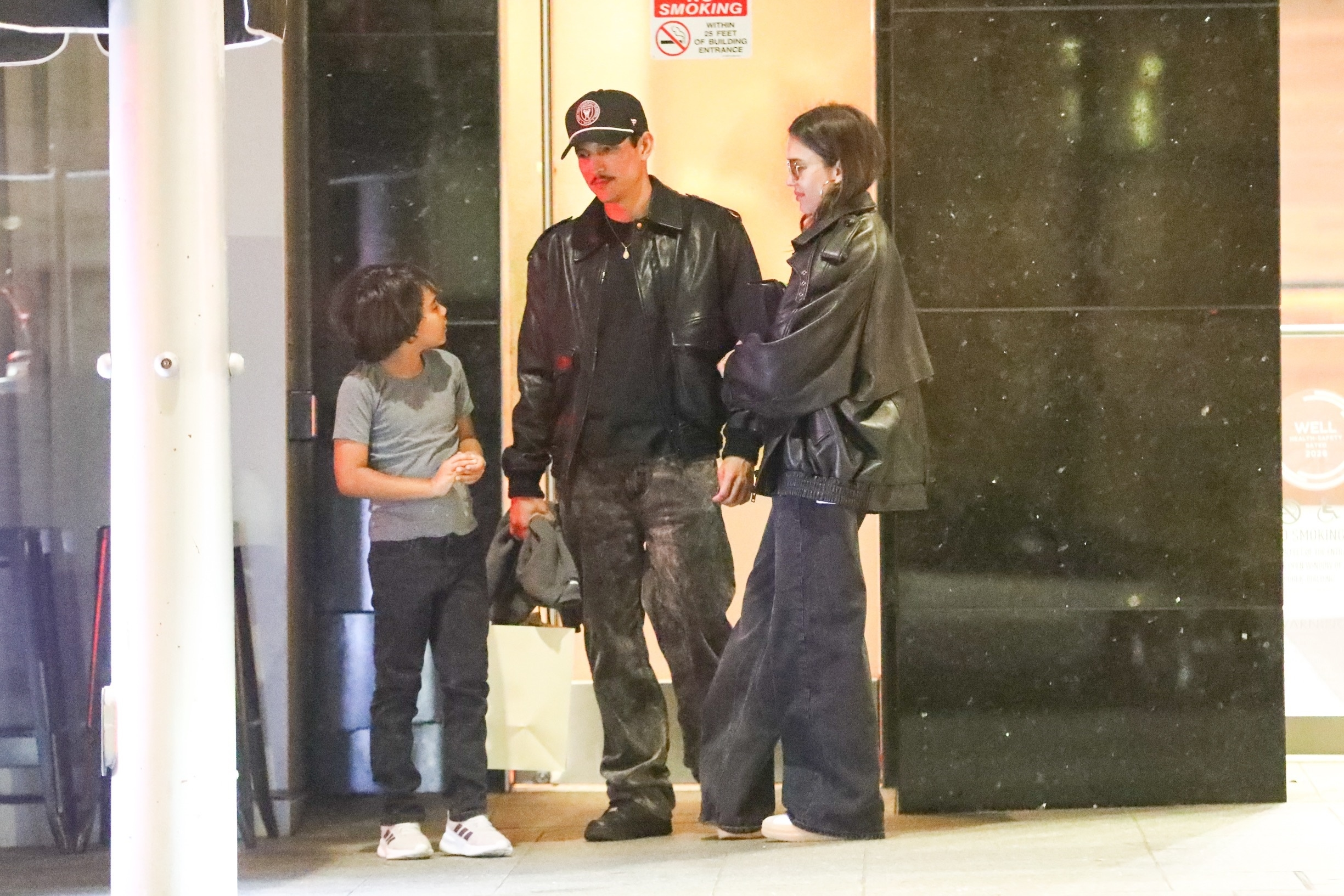 Jessica Alba with Danny Ramirez as her son Hayes tucks under her jacket outside Avra.